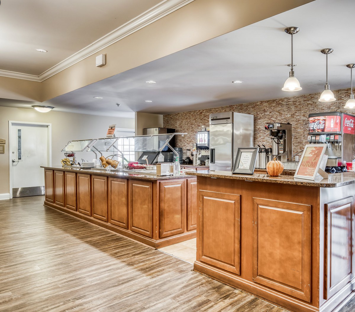 A modern cafe interior with a wood-finished counter and stylish lighting.