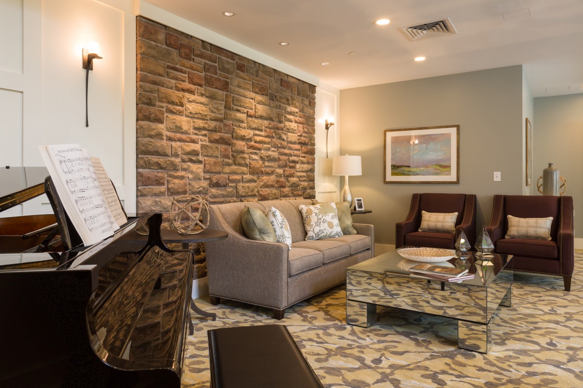 A cozy living room featuring a brick accent wall, comfortable seating, and stylish decor.