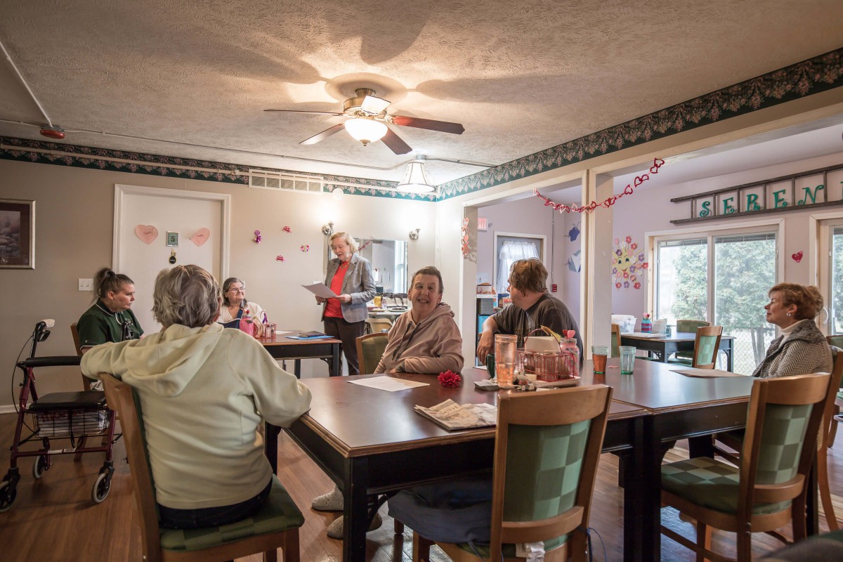 A group of people gathered around tables in a decorated indoor setting.
