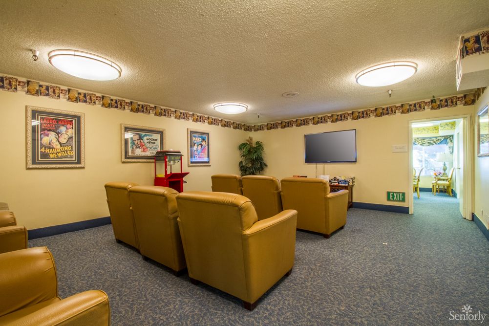 A cozy theater room with comfortable seating and a large television.