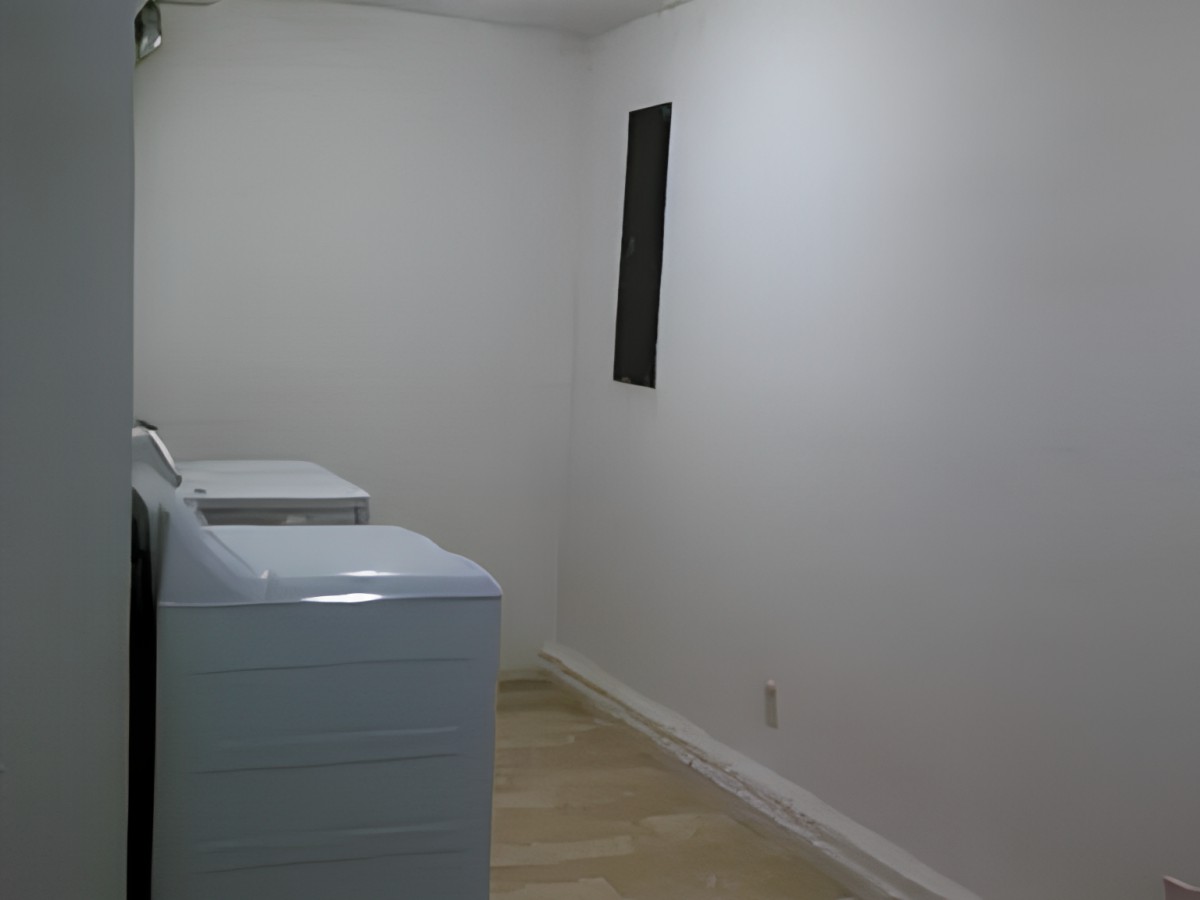 A minimalist laundry room with a washer and dryer against white walls.