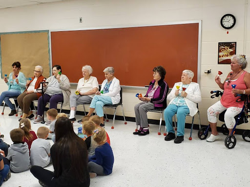 Seniors engaging with children in a community storytime session.