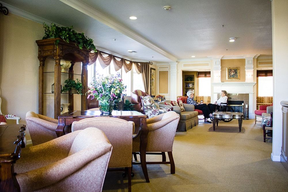 A luxurious living room featuring elegant furniture and decor with a seating area and greenery.