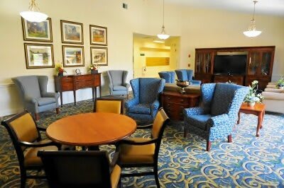 A cozy living room with various chairs, a round table, and decorative wall art.