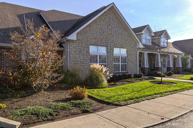A suburban residential house with a well-maintained front yard and brick exterior.
