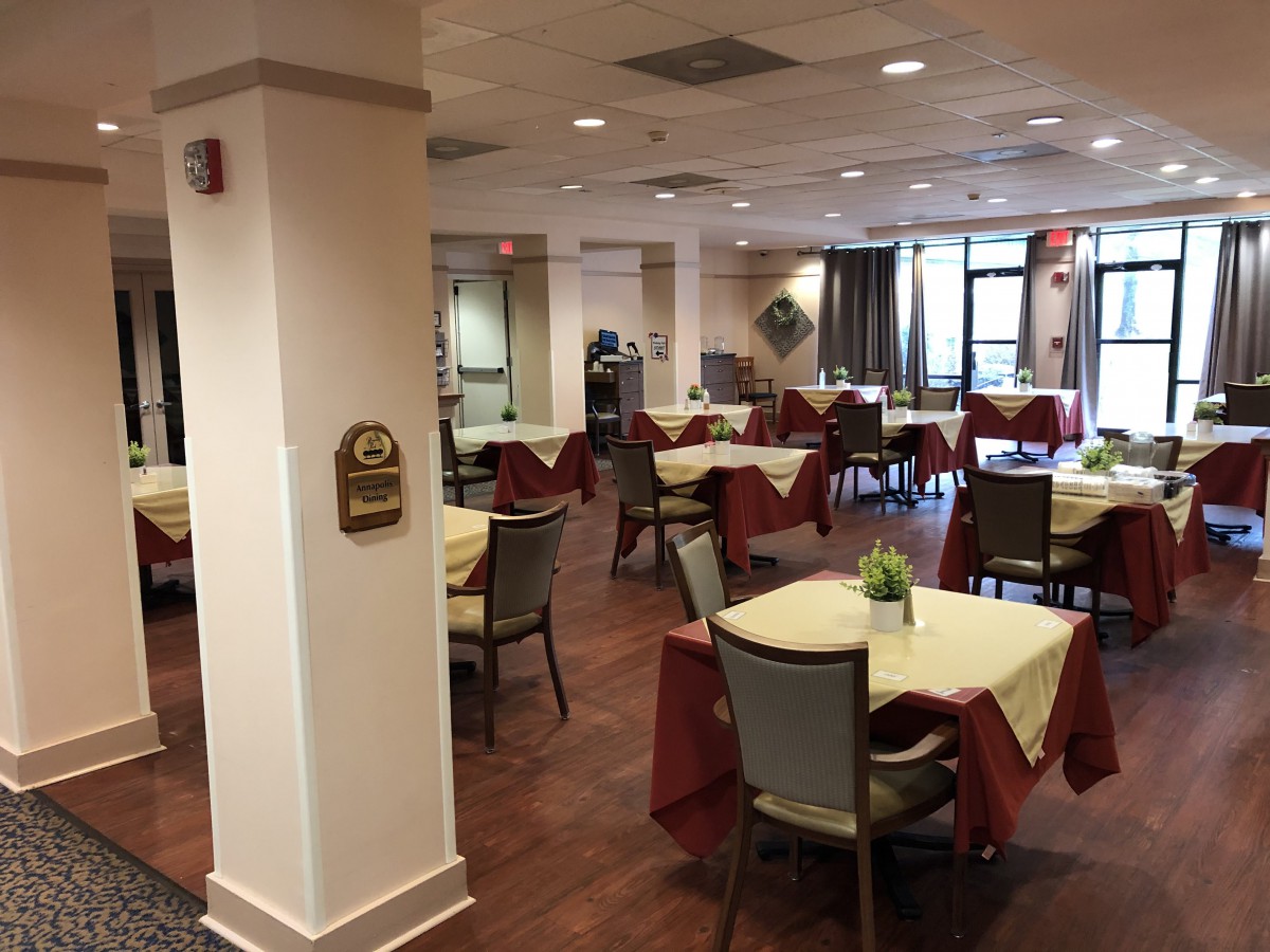 An empty dining room with neatly arranged tables and chairs.