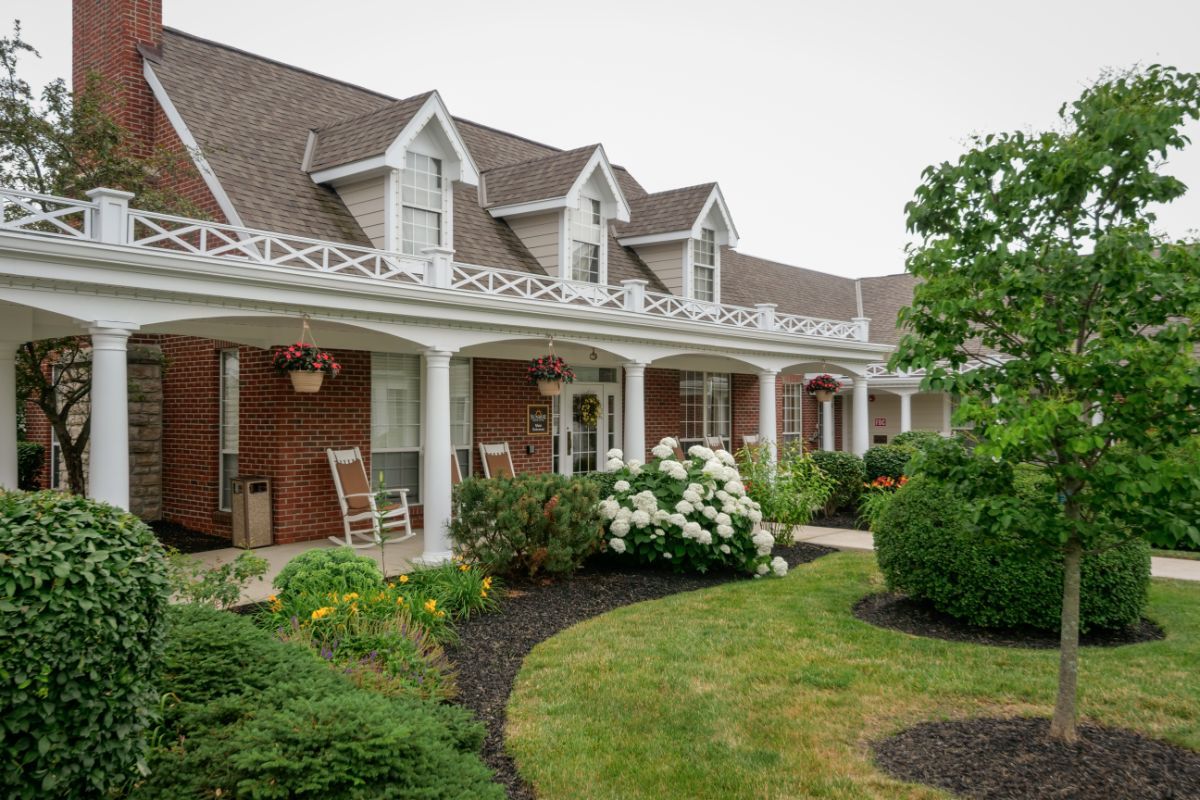 A charming house with a large front porch and well-maintained garden.
