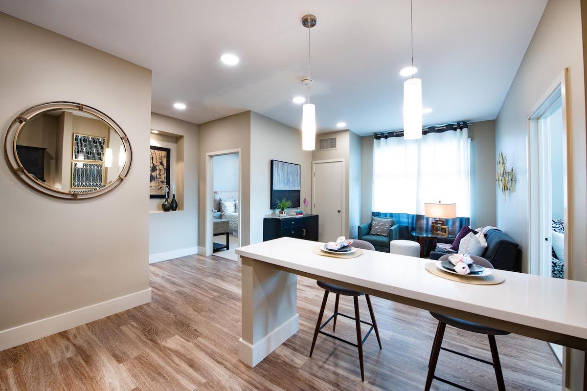 A modern open-concept kitchen and living room with an island counter and bar stools.