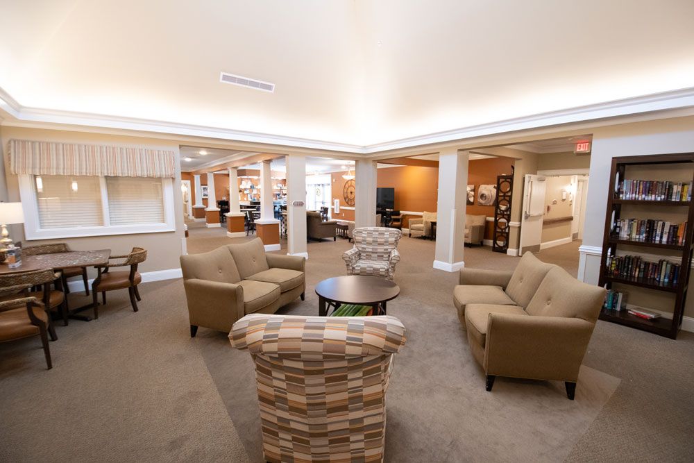A spacious and well-lit lobby with comfortable armchairs and a central coffee table.
