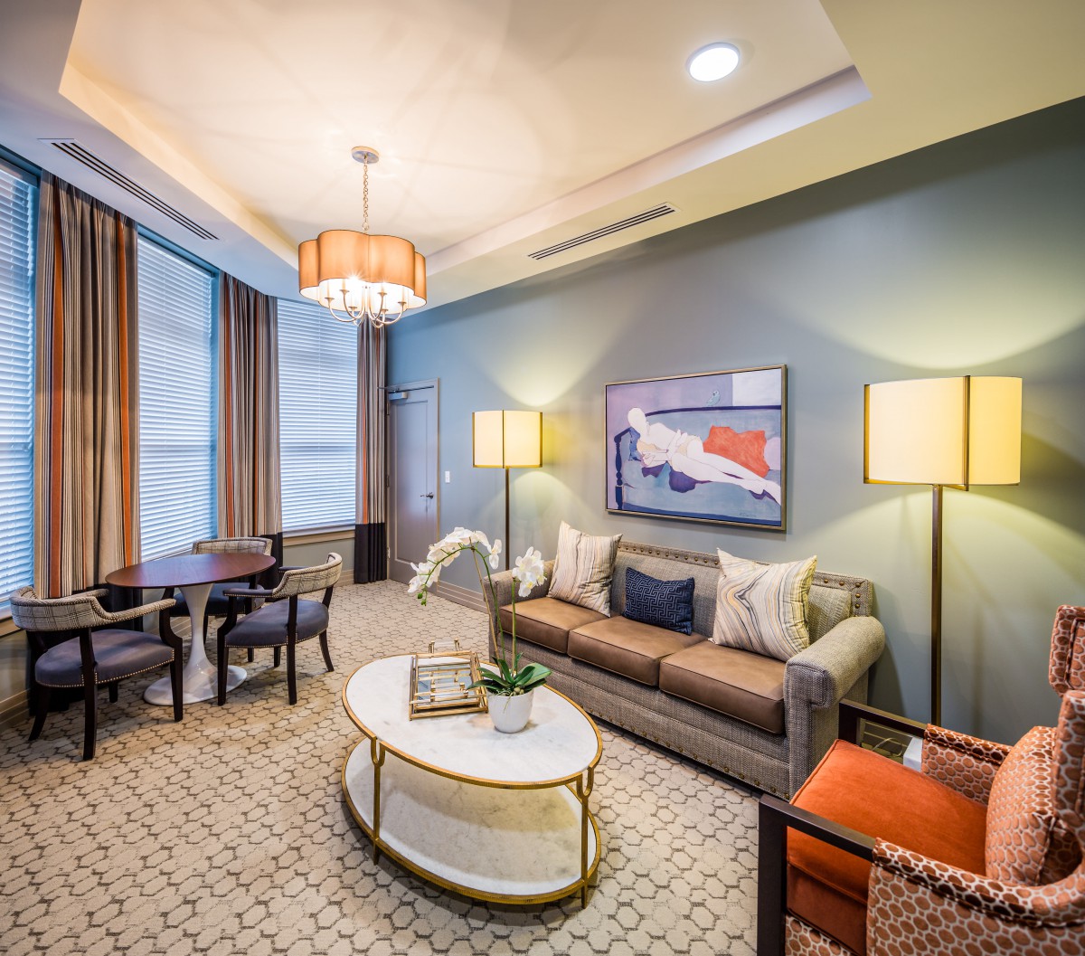 A modern living room with elegant furnishings, featuring a sofa, coffee table, and decorative lamps.