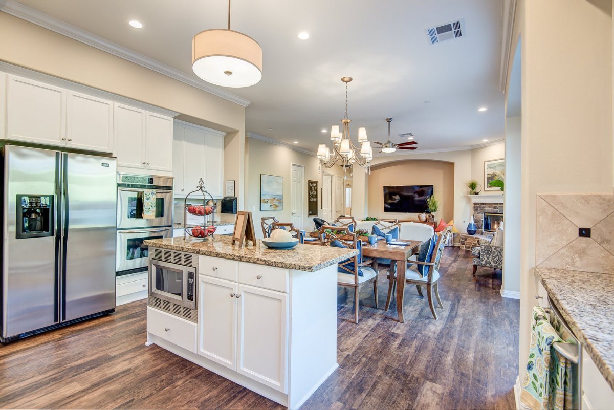 Modern open-concept kitchen and dining area with sleek design and hardwood floors.