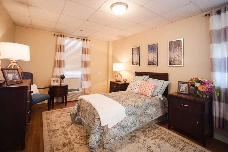 A cozy bedroom interior with a well-made bed, side tables, and soft lighting.