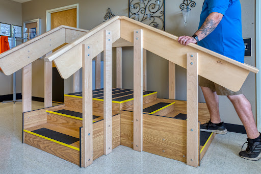A wooden staircase with a handrail, designed for indoor use, featuring steps marked for safety.