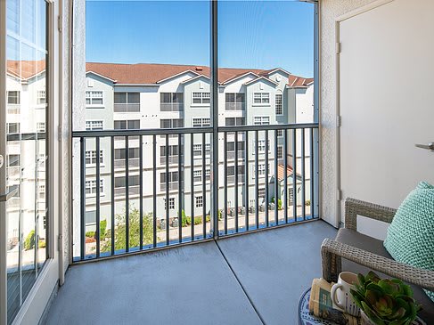 A balcony overlooking neighboring apartment buildings with a clear sky.