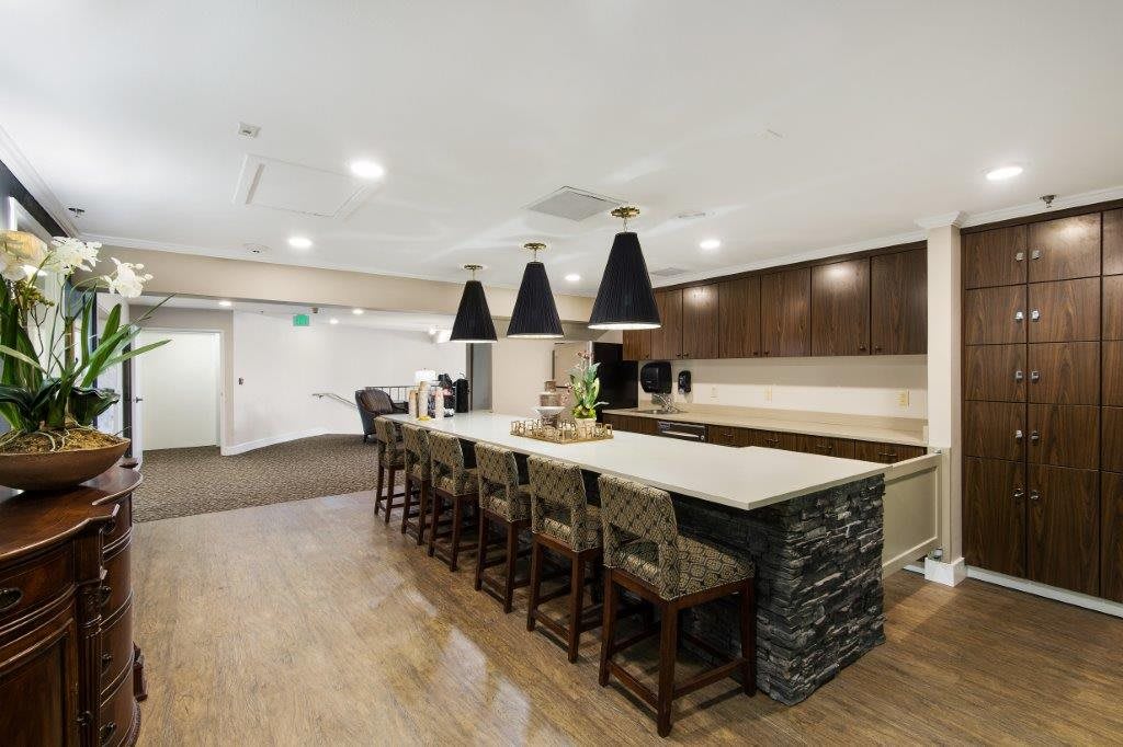 A modern kitchen with a bar counter and pendant lighting.