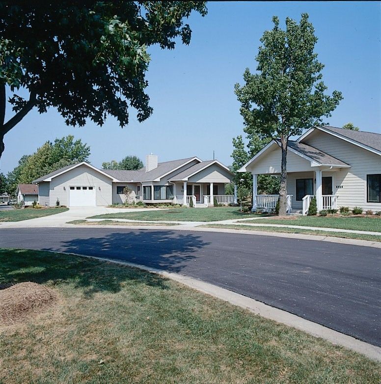 A quiet suburban neighborhood with neatly arranged houses and well-maintained lawns.