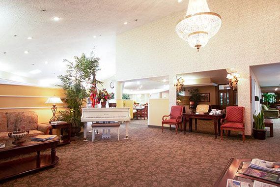 A spacious lobby with elegant decor, featuring a chandelier and seating area.
