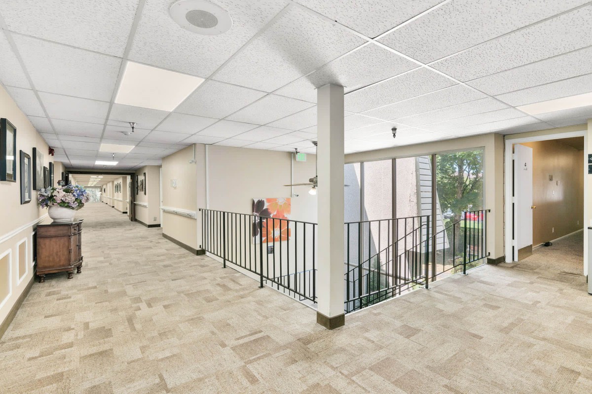 A well-lit interior hallway in an office building with stairs and corridor.
