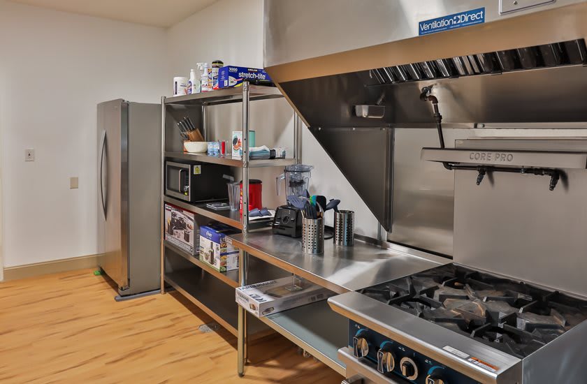 A clean and organized commercial kitchen space with stainless steel shelves and appliances.
