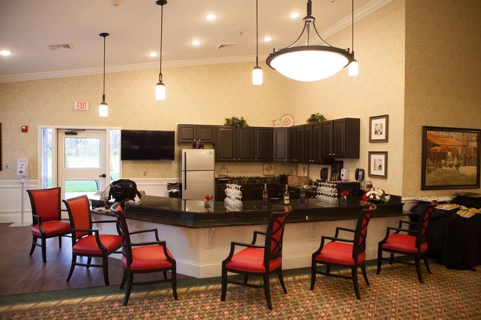 A modern kitchen area with bar seating and pendant lighting.