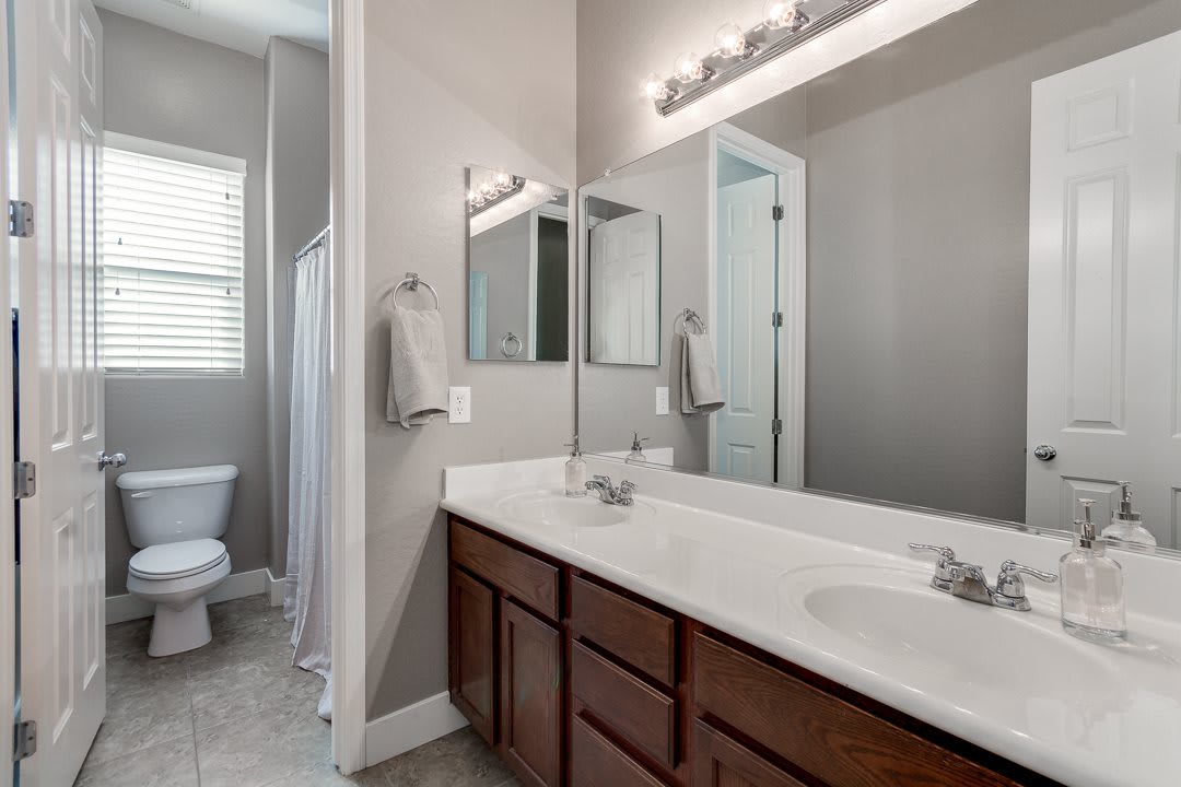 A modern bathroom featuring a double sink vanity, large mirror, and a walk-in shower.