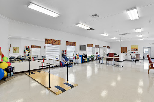 A spacious and modern rehabilitation center for physical therapy, featuring various exercise equipment and an open layout.