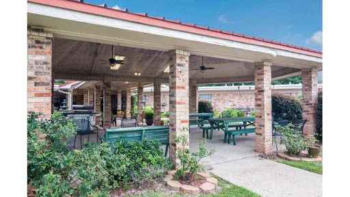 A cozy outdoor dining area featuring spacious seating and a charming brick structure.