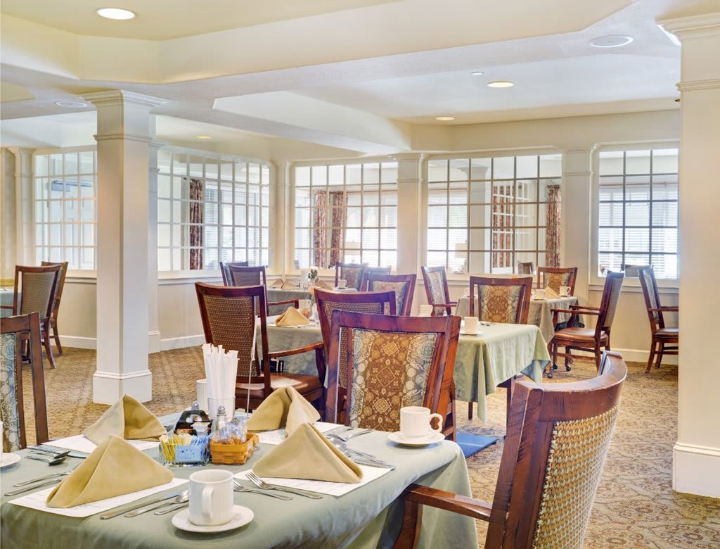 An elegantly set dining room with neatly arranged tables and chairs.