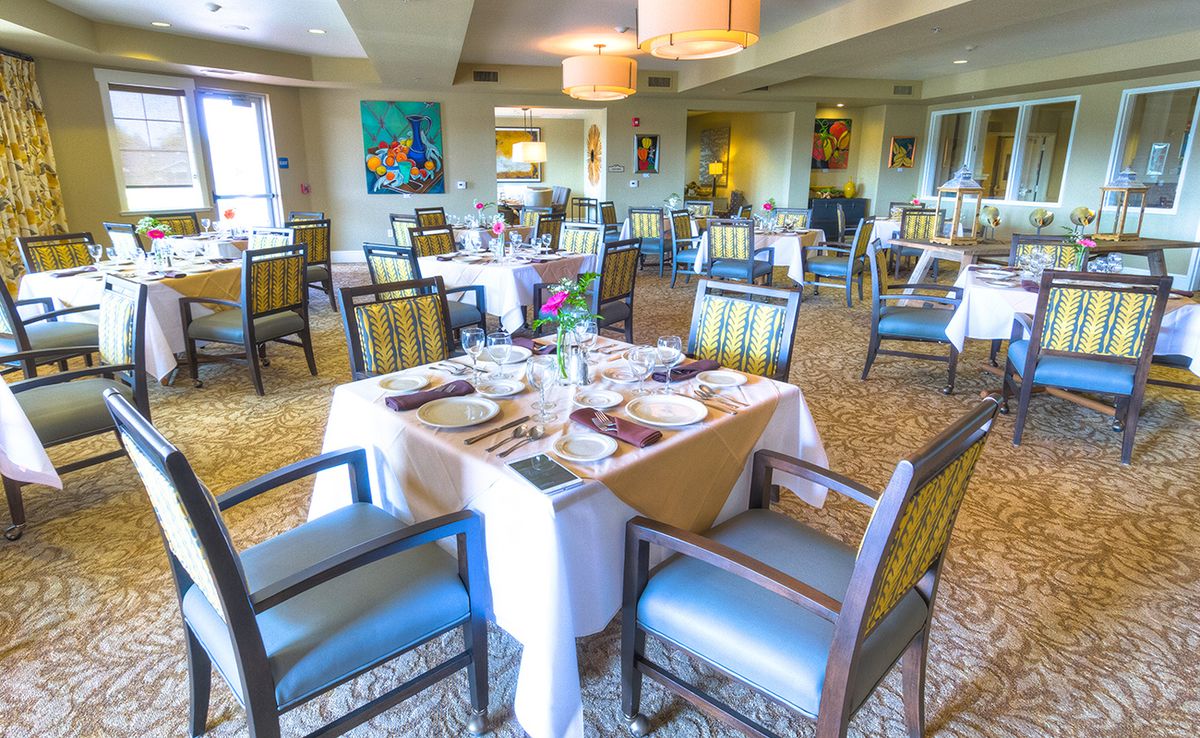 A well-decorated restaurant dining room with elegantly set tables and comfortable chairs.