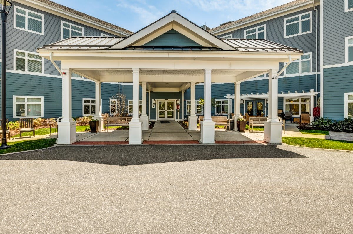 A grand building entrance with a covered porch and elegant columns.