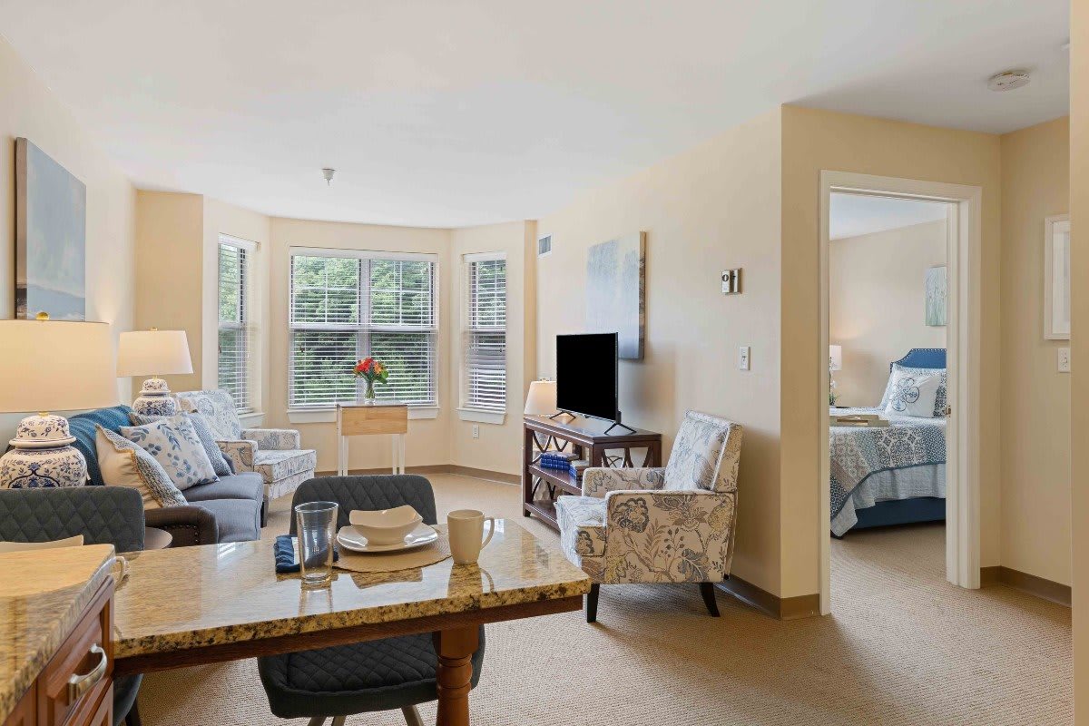 A bright and comfortable living room with cozy furniture, a television, and a dining area.
