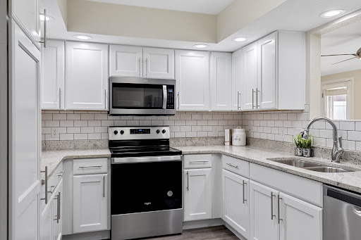 A modern kitchen featuring sleek white cabinets and stainless steel appliances, perfect for both functionality and style.
