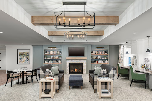A cozy and modern living room featuring stylish furniture, a warm fireplace, and ample shelving for books.