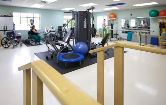 A well-equipped gym space featuring various fitness machines and rehabilitation equipment.