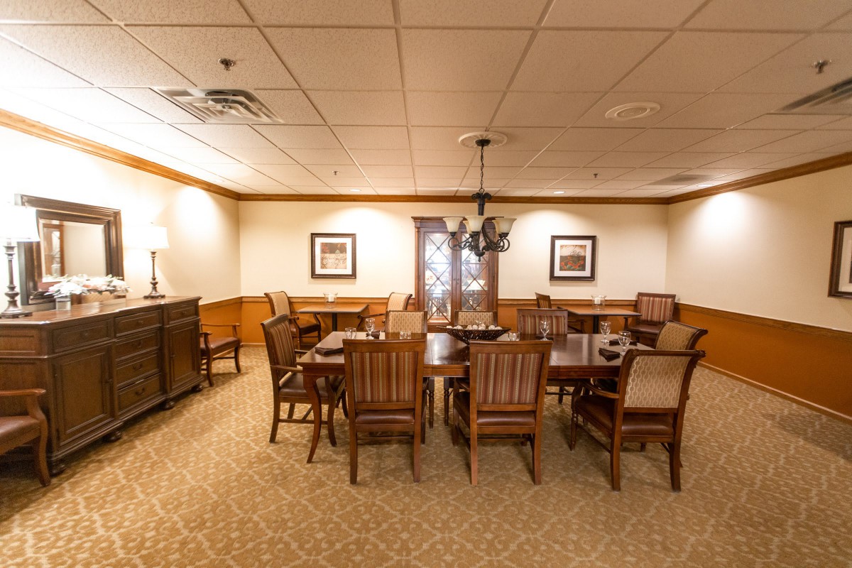 A cozy dining room with wooden furniture and a chandelier.