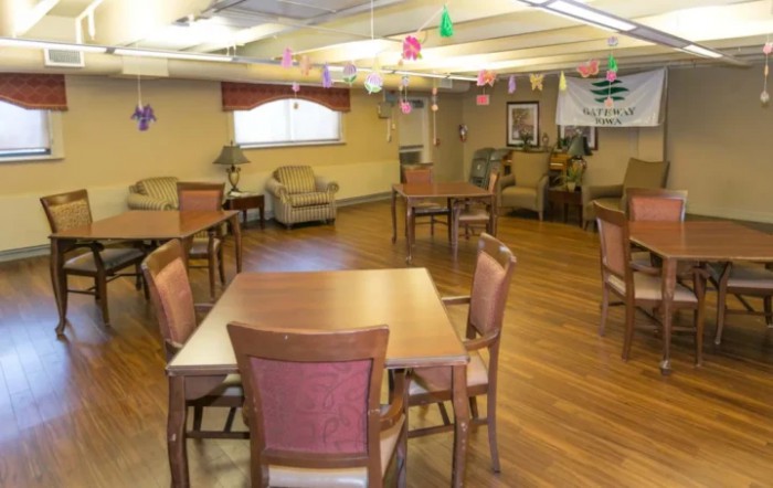 A well-lit community room with tables and chairs arranged for social gatherings.