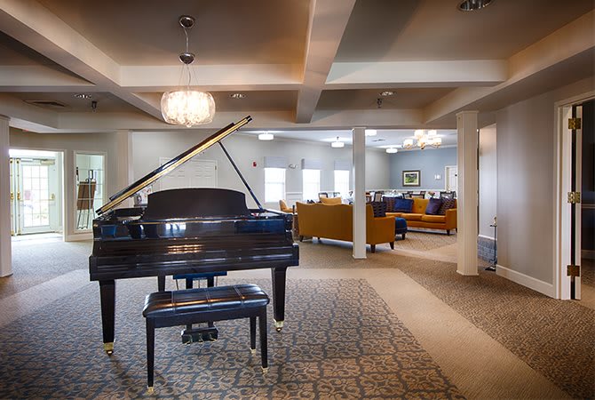 A spacious lounge with a grand piano and comfortable seating areas.