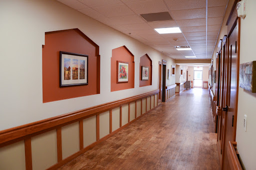 A well-lit hallway featuring framed photographs and a wooden floor, enhancing the inviting decor.