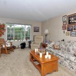 Cozy living room with a floral sofa, coffee table, and large window.
