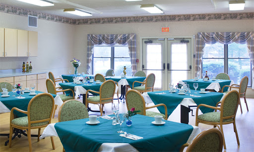 A spacious dining area with neatly set tables featuring blue tablecloths, ready for guests.