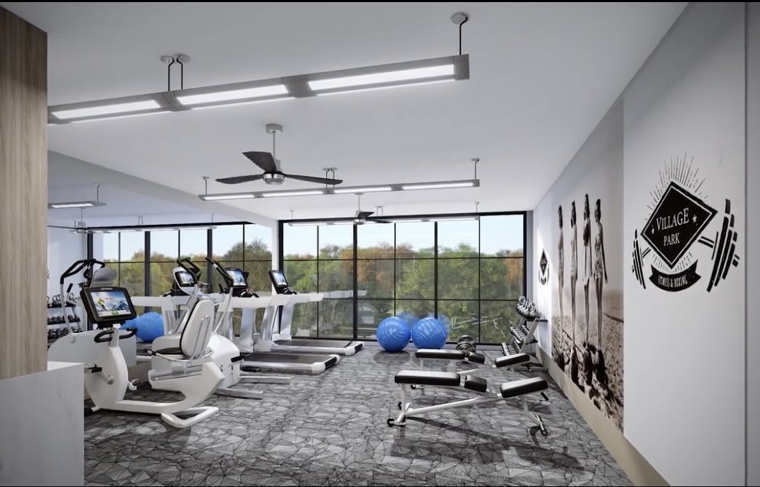 A modern fitness center with treadmills, weights, and yoga balls next to large windows.