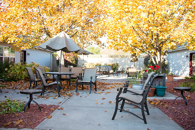 A peaceful patio area decorated with autumn leaves and outdoor furniture, perfect for enjoying a crisp fall day.