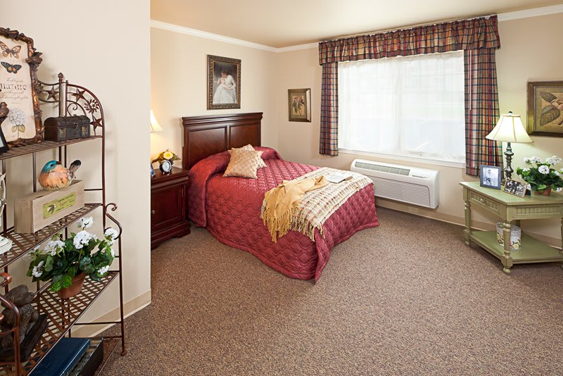 A cozy bedroom with a neatly made bed and large window.