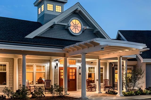 A beautifully illuminated house with a welcoming porch at dusk.