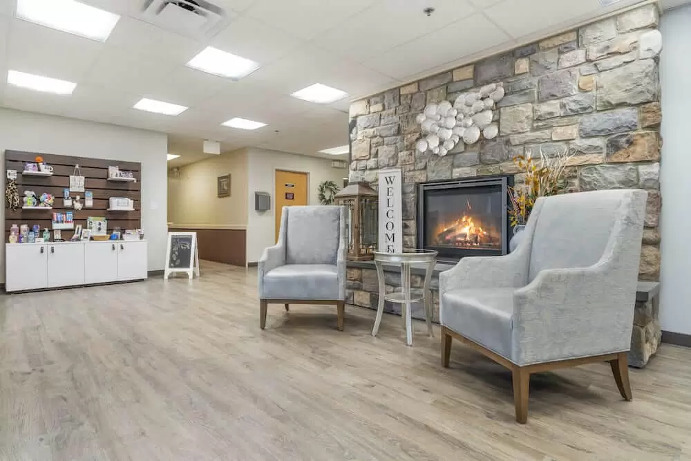 A cozy lobby interior with modern chairs and a stone fireplace.