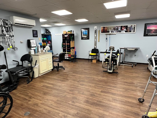 A well-equipped physical therapy clinic featuring exercise equipment and a comfortable waiting area.