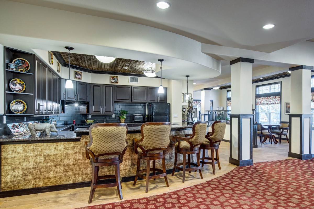 A cozy kitchen bar area with elegant seating and warm lighting.