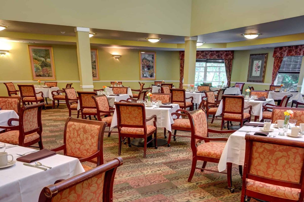An empty dining room with neatly arranged tables and chairs.
