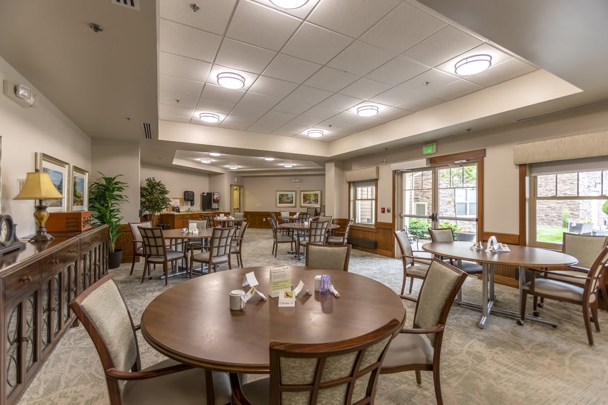 A spacious dining area with elegant tables and chairs, featuring warm lighting and tasteful decor.