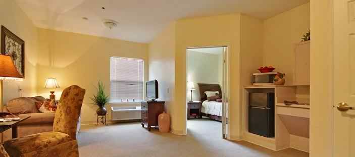 A cozy living room with a television, leading into a bedroom.